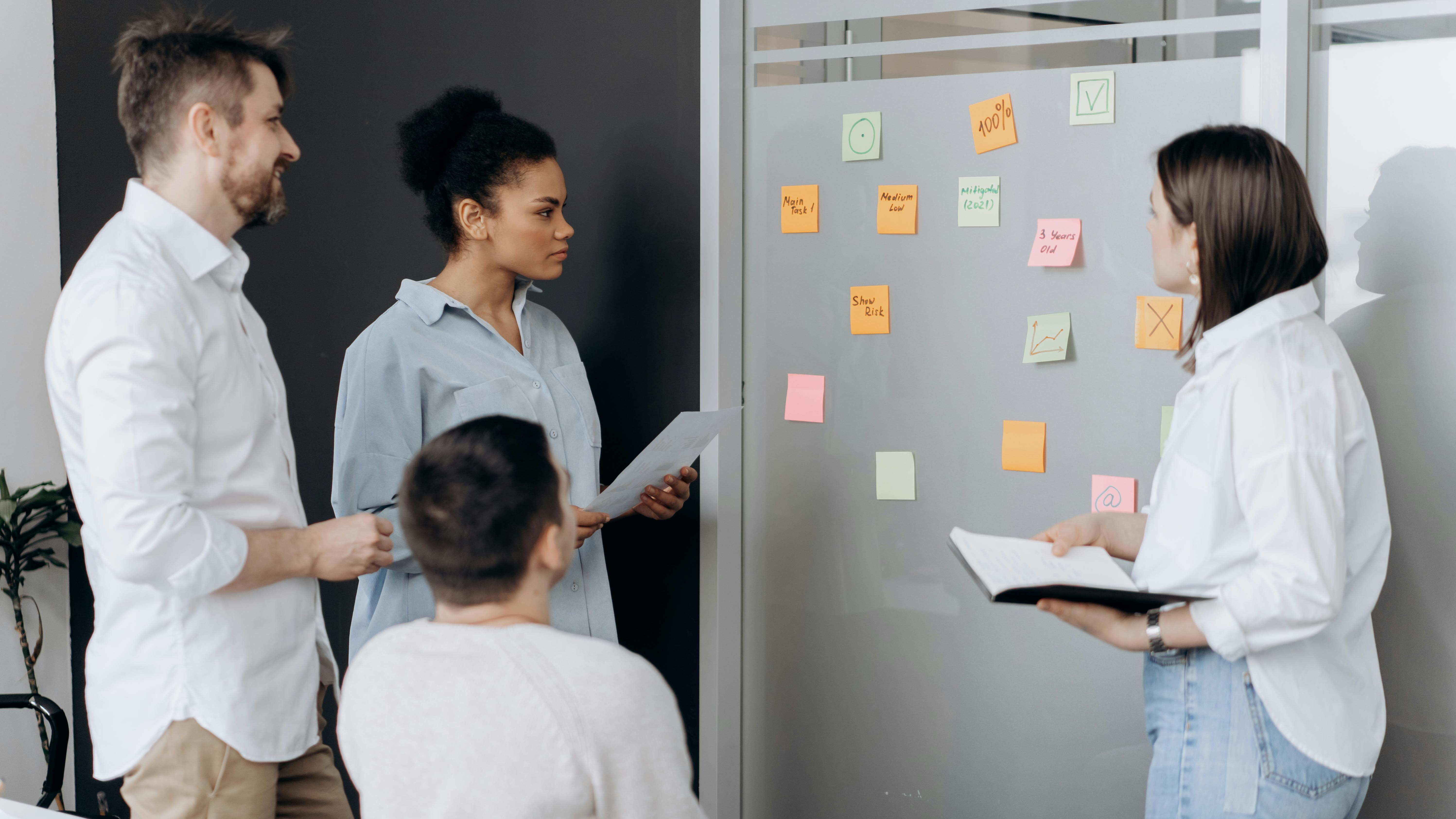 Ein Team von mehreren Personen steht vor einer Pinnwand