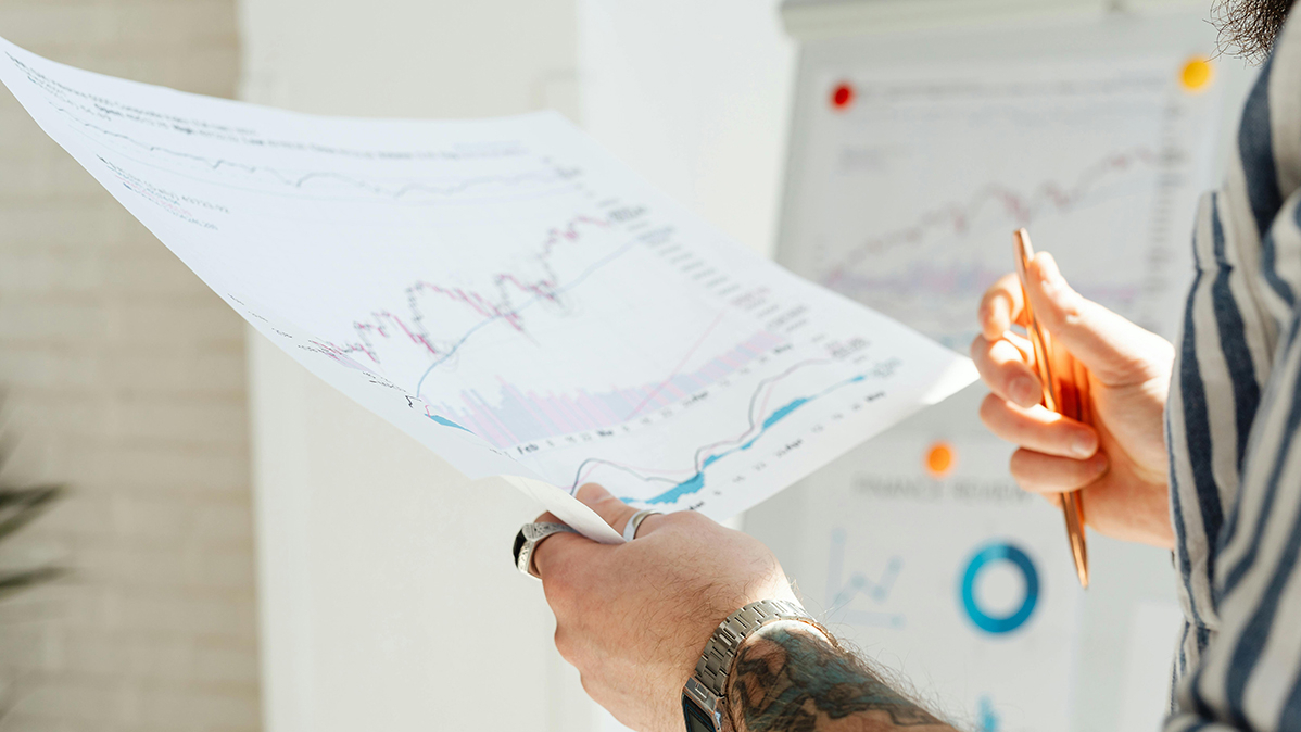 Man sieht einen Person die ein ausgedrucktes Diagramm in den Händen hält.