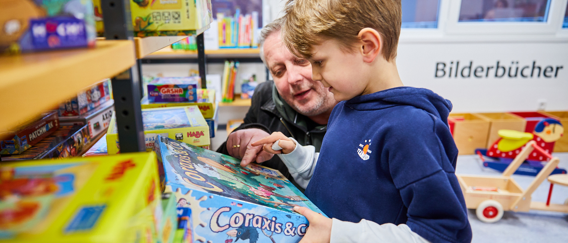 Ein Mann und ein kleiner Junge begutachten ein Gesellschaftsspiel