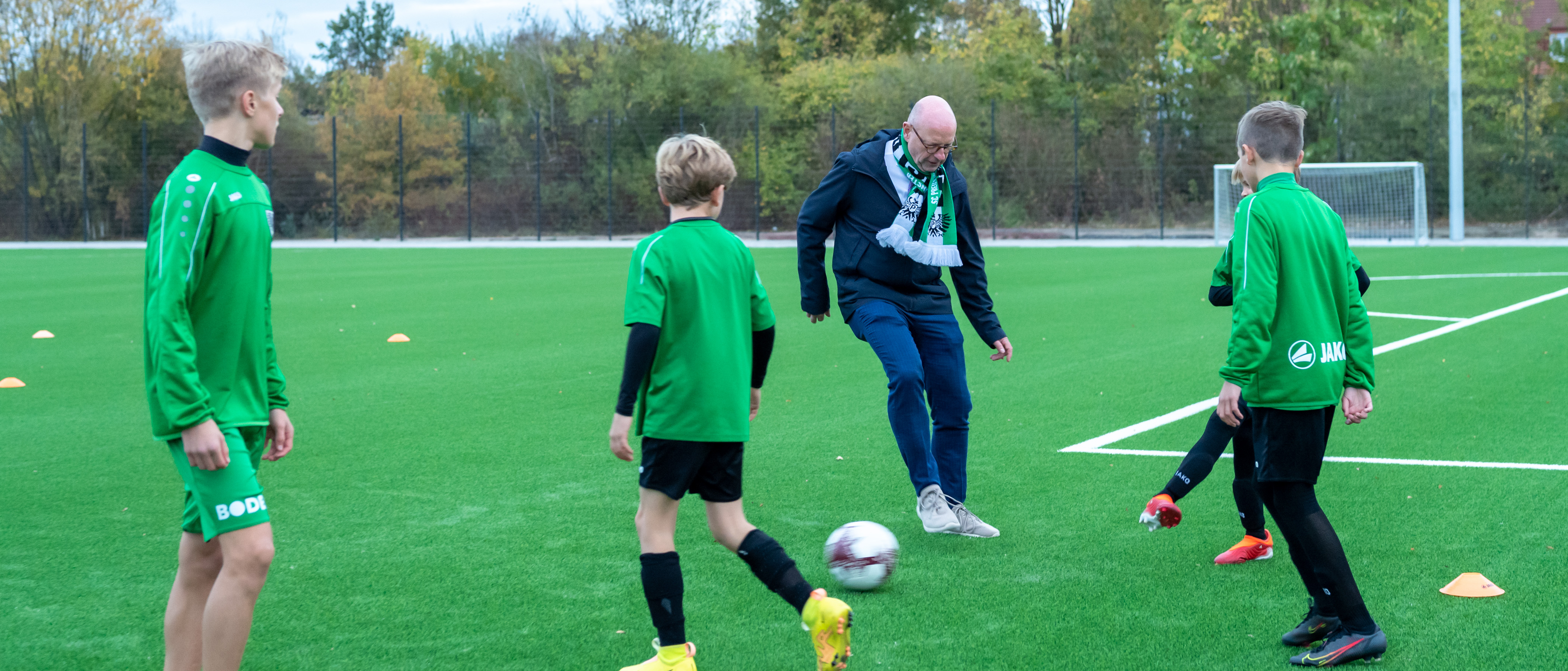 Oberbürgermeister Markus Lewe mit jungen Kickern auf dem Kunstrasenplatz im Sportpark Berg Fidel