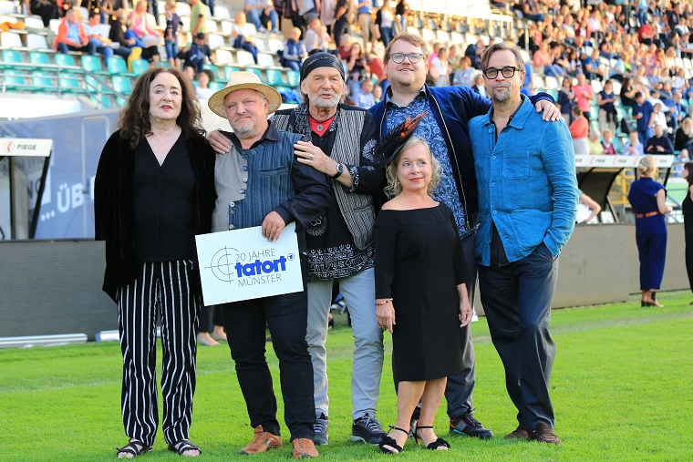 Sechs Personen vor der Zsuchauertribüne im Stadion