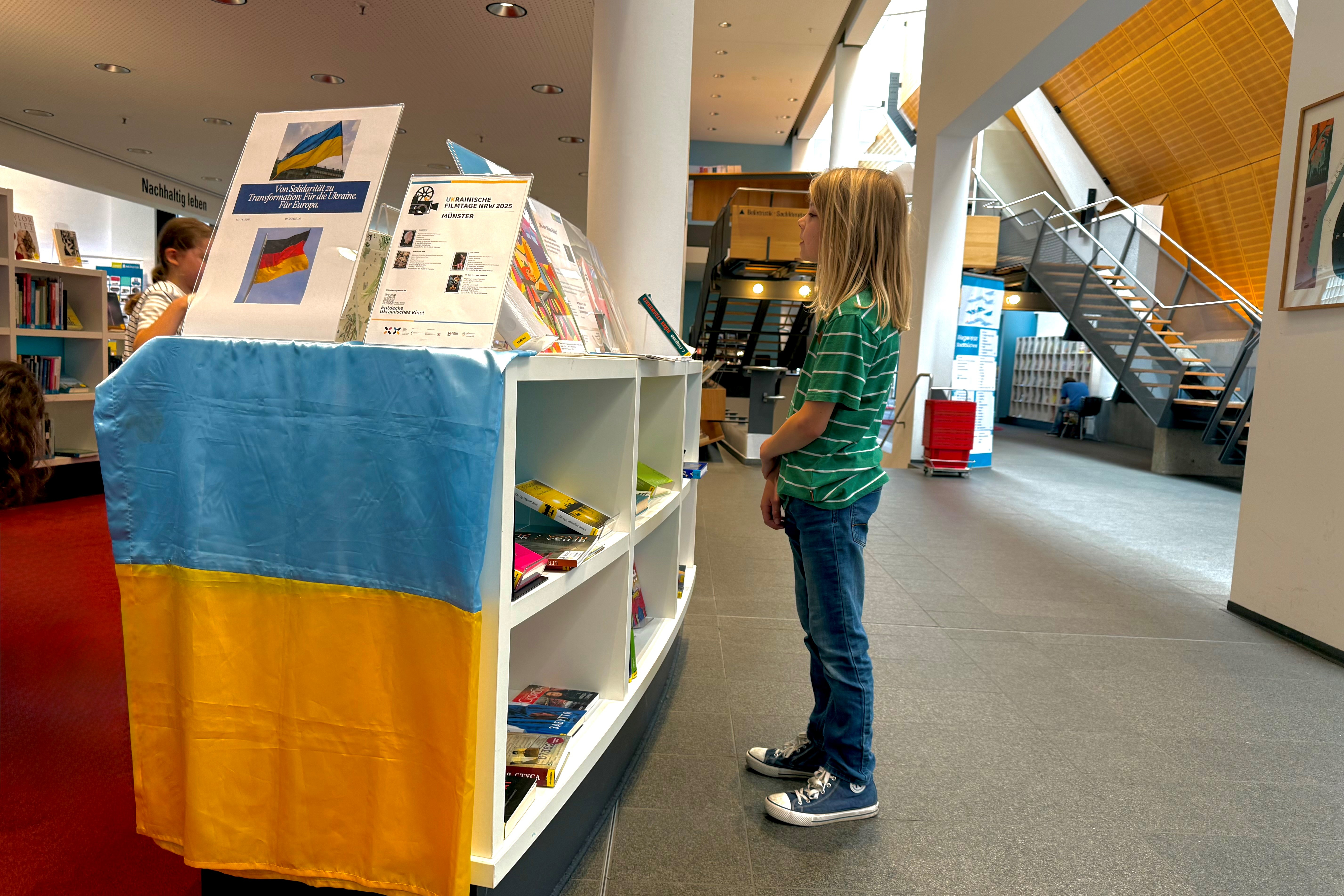 Kleiner Junge schaut sich in der Bücherei um