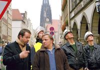 Auf dem Prinzipalmarkt stehen  Kommissar Frank Thiel (Axel Prahl) und Rechtsmediziner Karl-Friedrich Boerne (Jan Josef Liefers) und schauen nach oben. Hinter ihnen stehen uniformierte Polizisten. Tatort 'Mörderspiele', Buch und Regie Stephan Meyer, Erstausstrahlung 2004, Foto: WDR/Michael Böhme