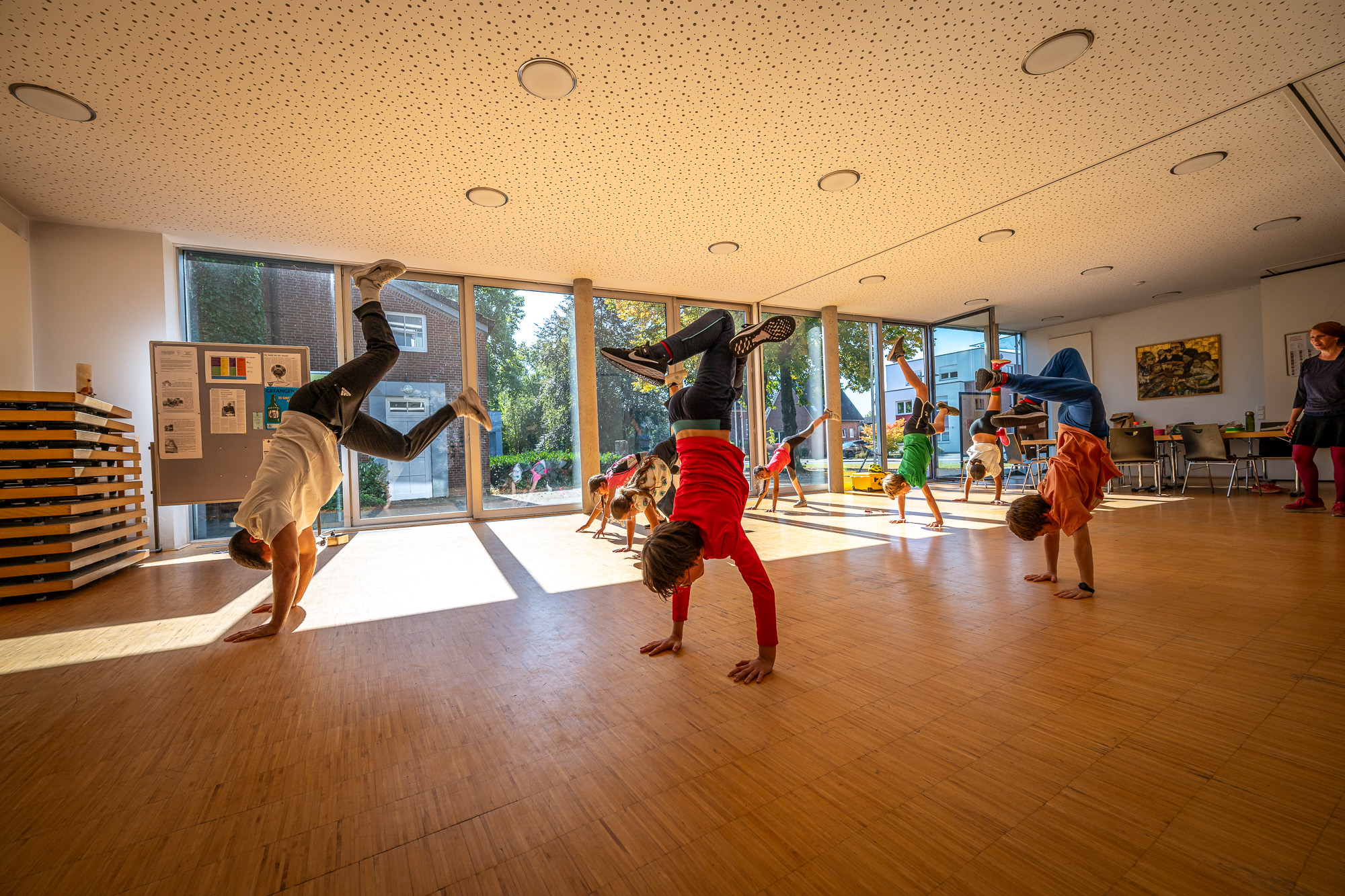 Kinder und Jugendliche tanzen in einem großen Raum. 