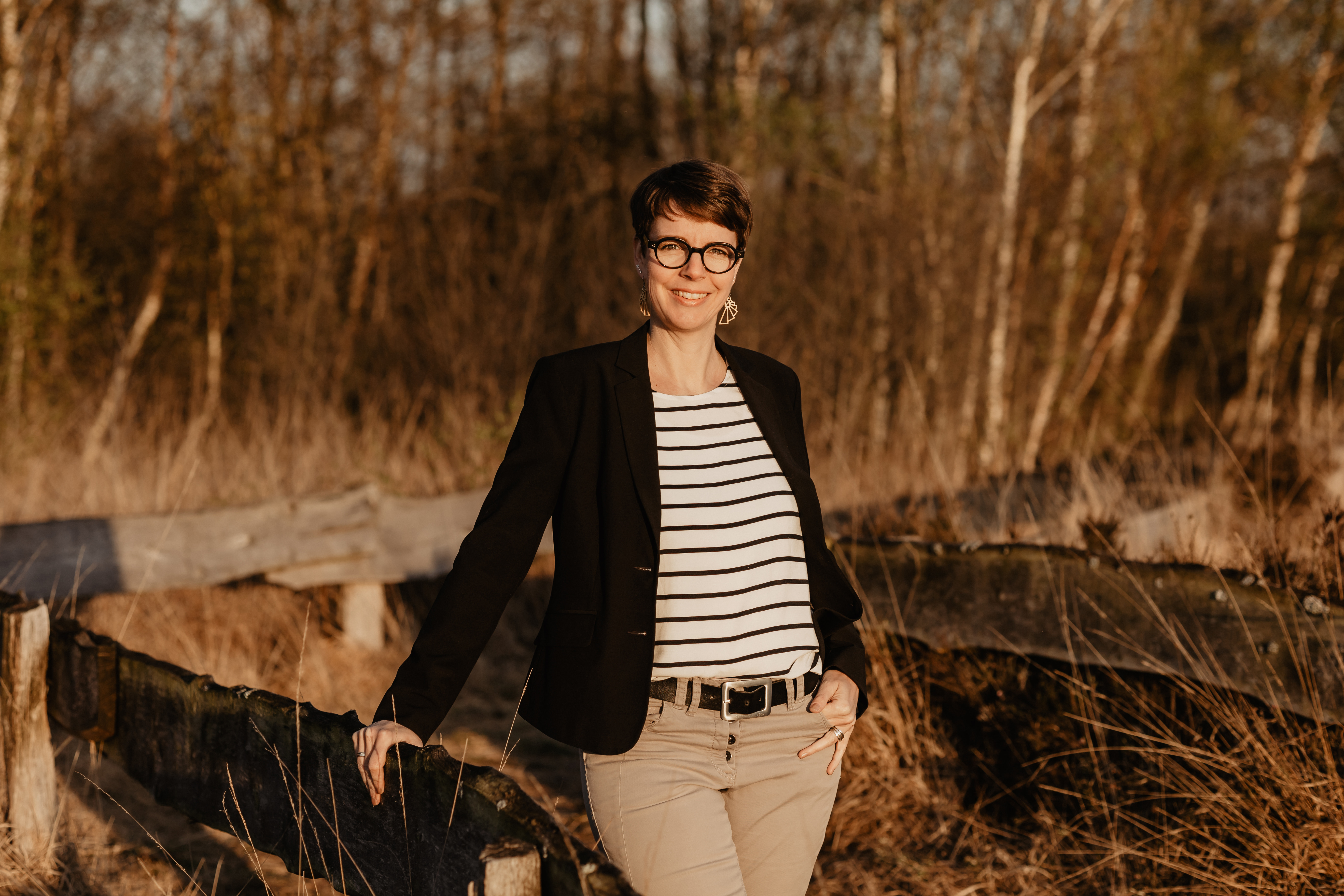 Frau mit gestreiftem Shirt und schwarzer Jacke mit Brille