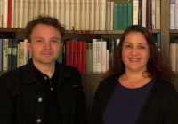 Das Team des Vorlese-Cafés Carsten Bender und Tanja Stermann stehen nebeneinander vor einem Bücherregal.