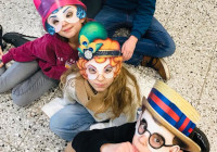 Fünf Darstellende des theaterXS, Ensemble 1 sitzen hintereinander auf dem Boden. Die Kinder tragen Masken und schauen nach oben in die Kamera.