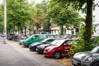 von Kfz zugeparkter Straßenraum am Hansaring - man sieht, dass die Autonasen so weit in den Radweg reinragen, dass dieser deutlich verschmälert ist (Quelle Stadt Münster)
