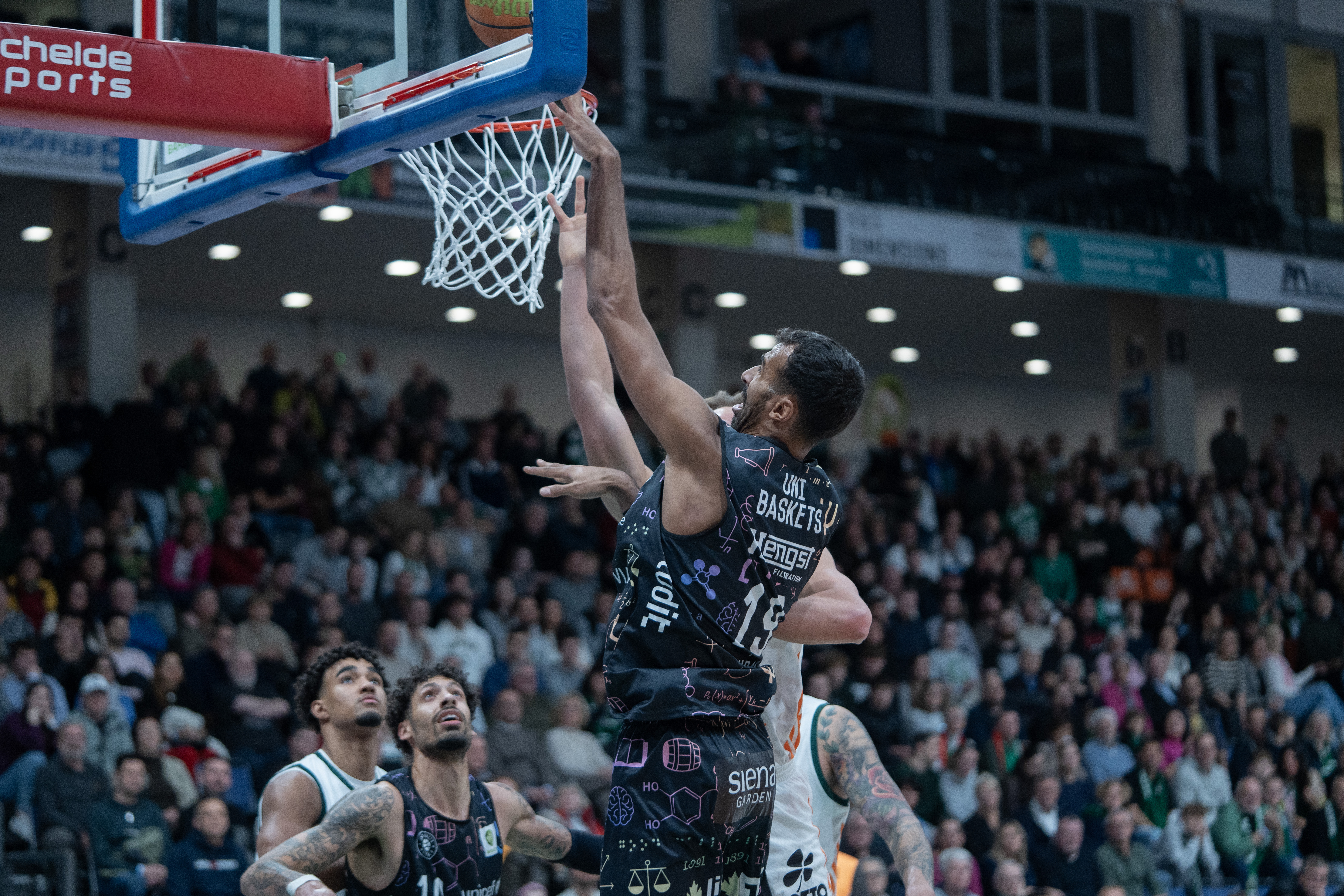 Ein Basketballer der Uni Baskets Münster steigt zum Dunk hoch.